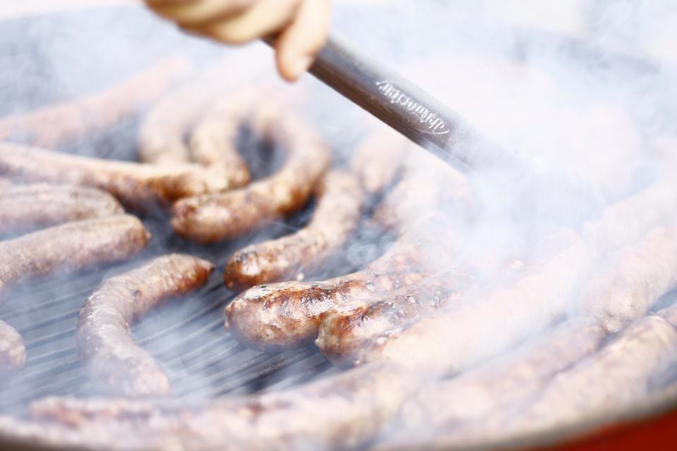 Salsicce sulla griglia allo stand gastronomico di una sagra
